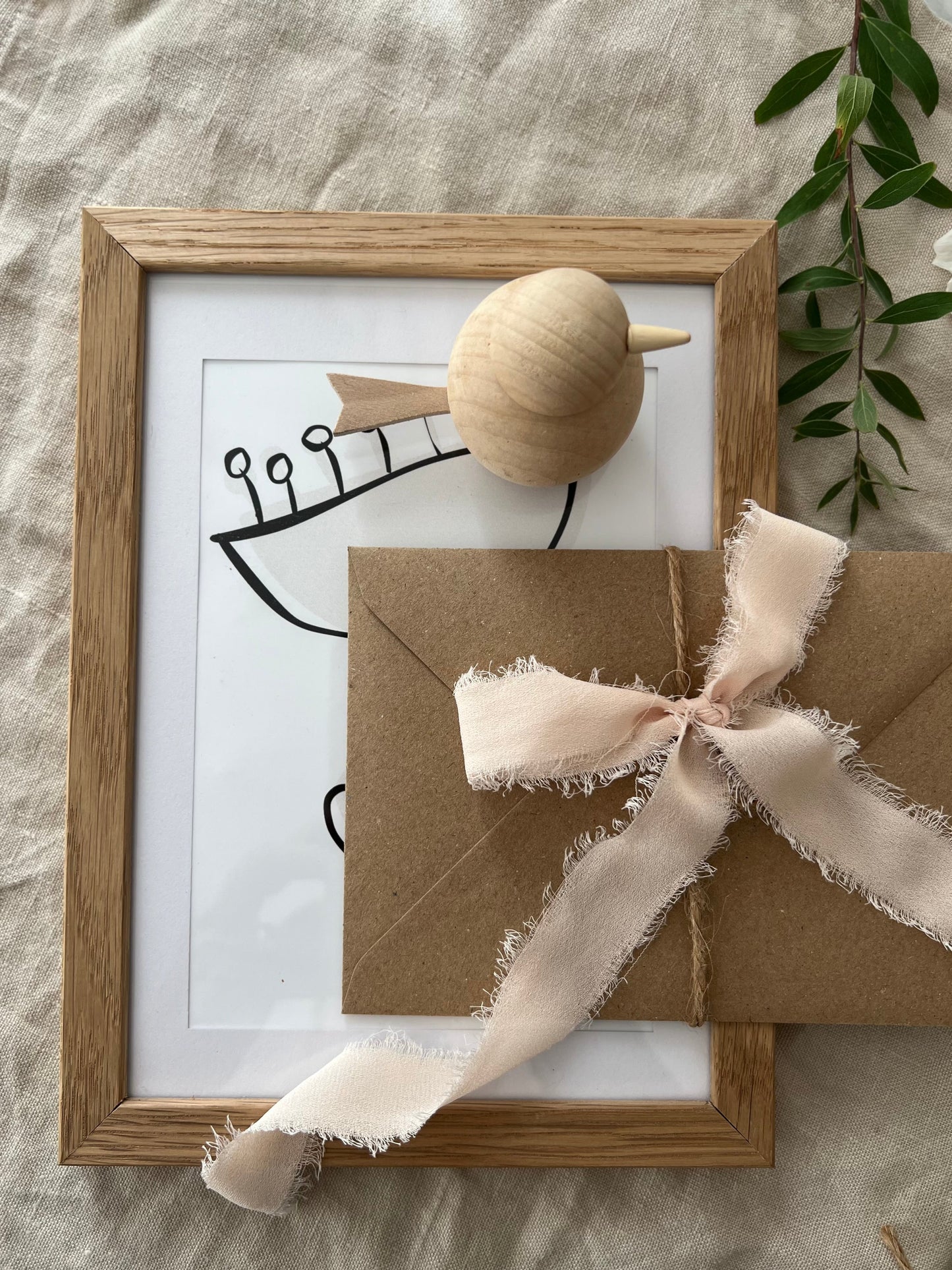 Framed artwork with a brown envelope and ribbon on a textured surface